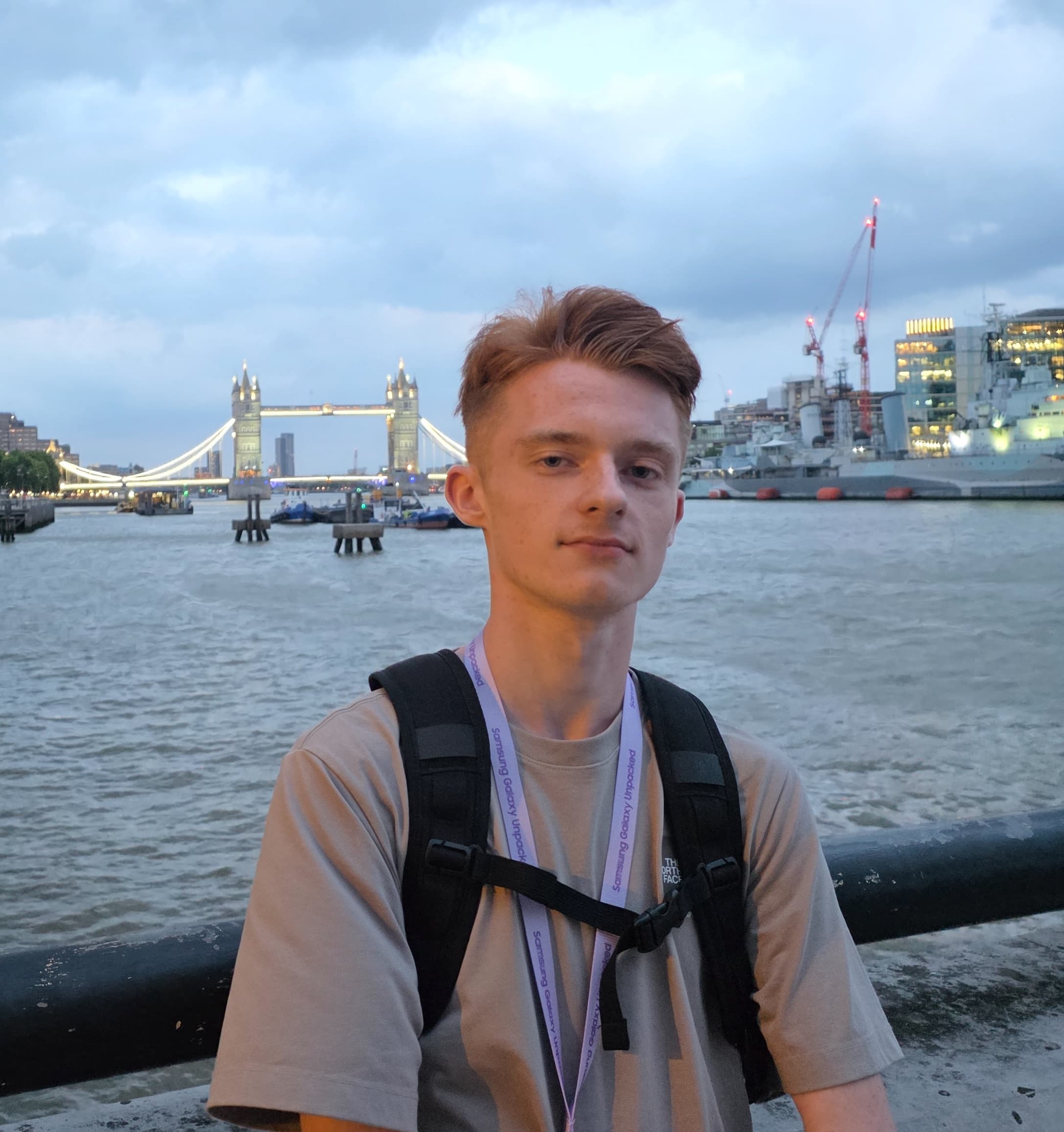 Josh Skinner beside the River Thames in London, with Tower Bridge behind him